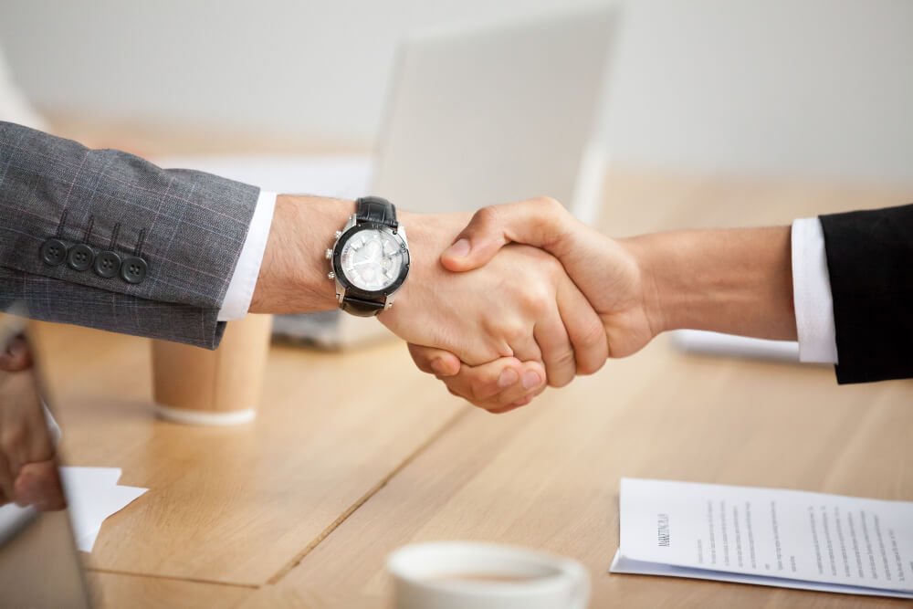 closeup view handshake two businessmen suits shaking hands1